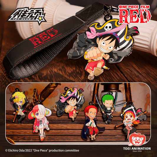 A One Piece: Film Red merchandise set featuring a black strap with red 'RED' text and a detailed character charm, alongside a collage of multiple chibi character keychains on a wooden background. Visible branding includes One Piece Film Red, Toei Animation, and Eichiro Oda copyright text.
